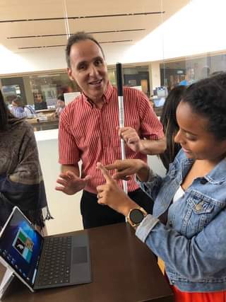 Foto de Manolo escuchando a una de sus estudiantes que le explica como hacer una seña.